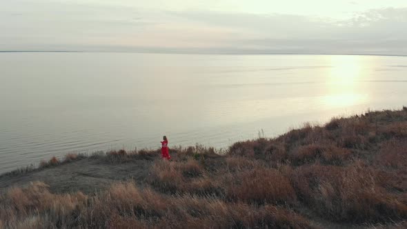 A Woman Warrior Standing on the Edge of Hill with Two Swords and Wields Them - a Landscape of Open