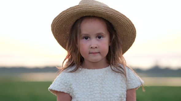 Portrait of Happy Little Girl in Straw Hat Smiling Closeup