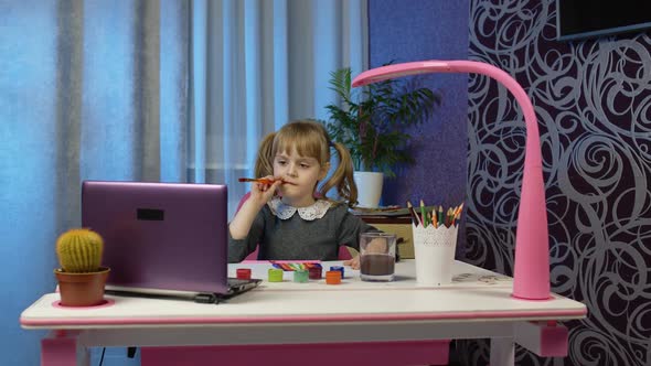 Child Girl Schoolgirl Enthusiastically Drawing with Brushes and Paints Distance Education at Home