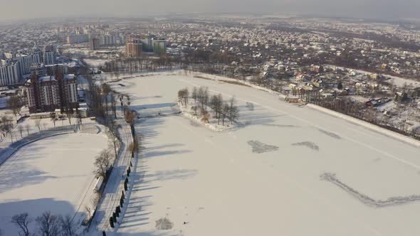 Aerial Drone View Frozen Lake in Park Under Snow