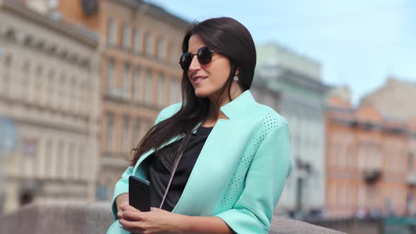 Attractive Young Fashion Woman in Sunglasses Enjoying Sunlight at Historical Building Background