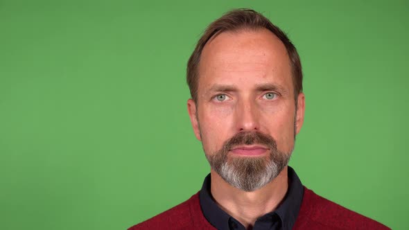 A Middleaged Handsome Caucasian Man Smiles at the Camera  Closeup  Green Screen Background