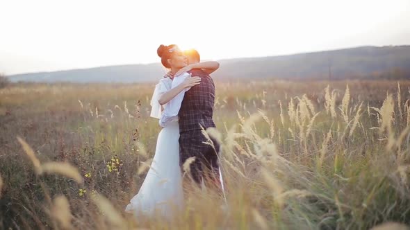 Shooting of Happy Young Caucasian Wedding Couple Which Hugging and Kissing in a Deserted Spikelet