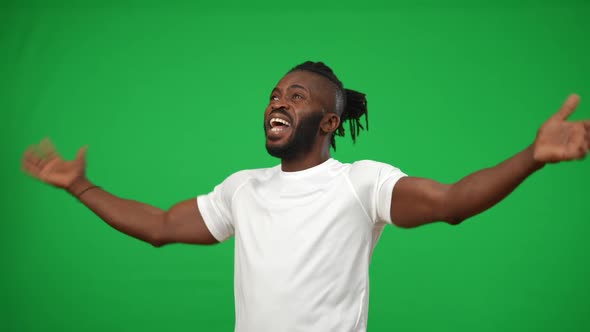 Portrait of Inspired Excited African American Sportsman Gesturing Victory on Green Screen Looking