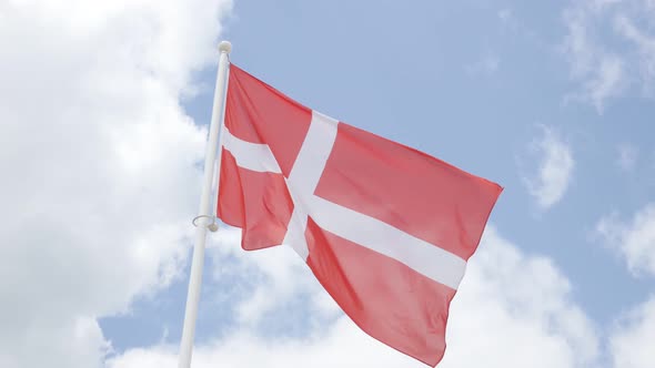 National flag of Denmark in front of cloudy sky waving 4K 2160p 30fps UHD footage - Red Danish flag  alt