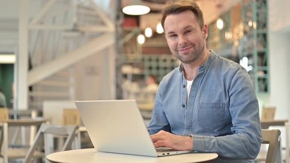 Casual Man with Laptop Shaking Head in Approval, Yes 