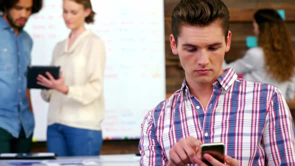 Business executive using mobile phone in meeting