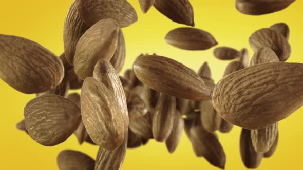 Flying of Almonds in Yellow Background