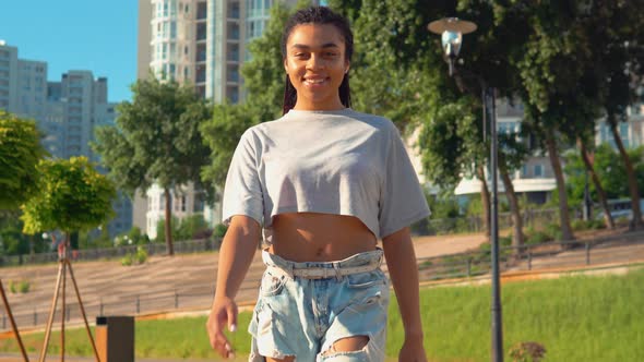 Attractive African American Woman Walks in Summer City