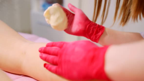 The Process of Hair Depilation on the Girl's Leg with Sugar Paste By a Professional Master