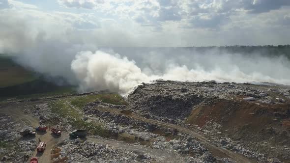 Garbage Dump Pollutes the Environment. Strong Wind Rises Toxic Smoke of Burning Garbage Into the Air