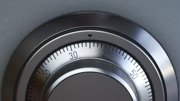 Mechanical dial combination safe full of gold bars mounted on a white wall.