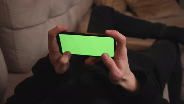 Man at Home Lying on a Couch using Smartphone 