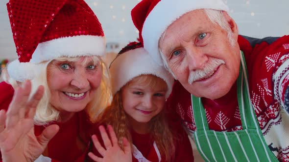 POV of Senior Grandparents with Grandchild Girl Taking Selfie on Mobile Phone on Christmas Kitchen