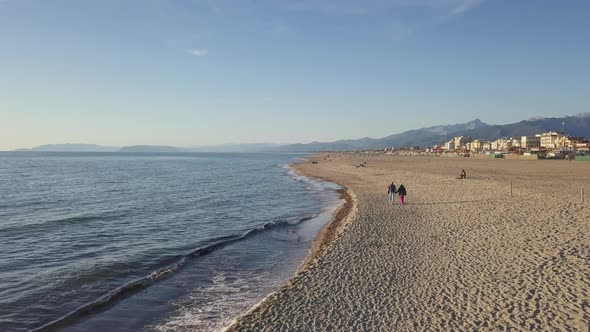 Elderly couple holding hands and enjoying retirement walking on a beautiful beach during sunset