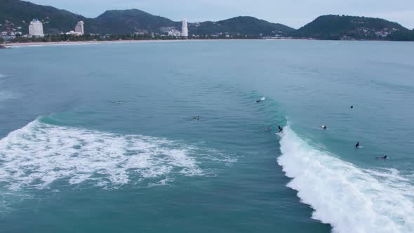 Top down of waves break on tropical sea Surfers with surfing boards Aerial drone view 4-k