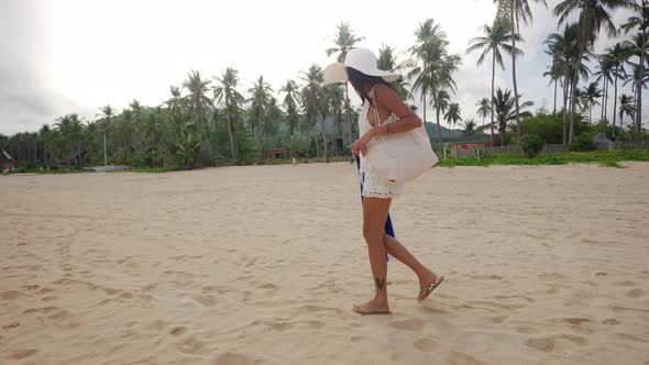 Woman In Sun Hat Walking On Nacpan Beach