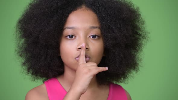 Young Cute African Girl with Finger on Lips