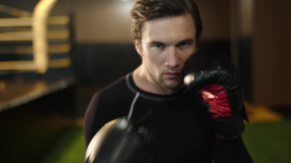 Eager Male Athlete Making Blows in Sport Club. Boxer Training Kicks at Gym