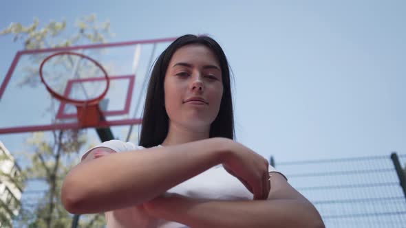 Portrait Cute Teen Brunette Girl Throws a Basketball Ball in the Ring Looking at the Camera Standing