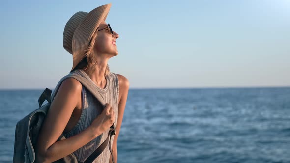 Laughing Backpacker Tourist Lady Walking on Beach Enjoying Sunset at Seascape Background