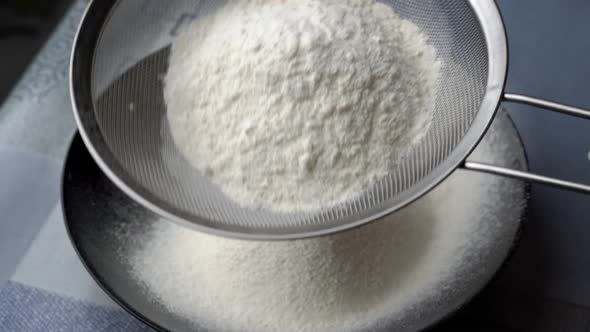 Young Girl Sifts Flour Through a Sieve Into a Baking Dish Closeup View