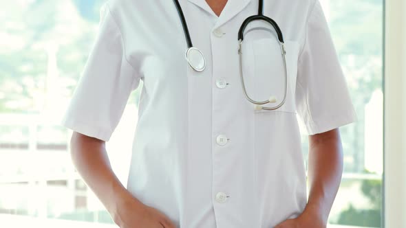 Happy doctor looking at camera with hands on pocket