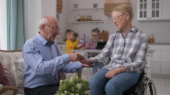 Caring Old Husband Developing Disabled Wife's Hand