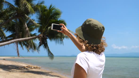 Woman Tourist Taking Photo Of The Beach Using Smartphone