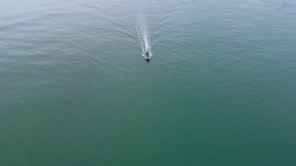 Aerial view from a drone of Thai traditional longtail fishing boats sailing in the sea.