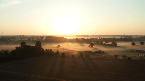 Morning with Fog on a Field in a Rural Area with Houses and a Field