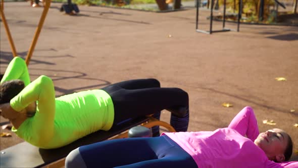 Fit couple working out abdominal exercises on sports ground in the morning