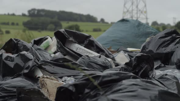 Illegal waste and garbage dumped in countryside close up panning shot