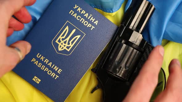 Man hand puts on Flag of Ukraine, handgun, passport, russia Ukraine war, Ukrainian victory