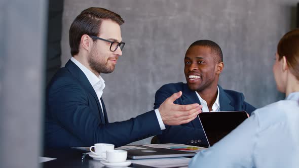 Business concept: young people applauding and smiling at a meeting