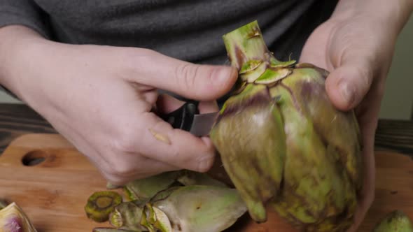 Woman Cleaning Artichokes with Knife