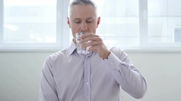 Businessman Drinking Water in Office