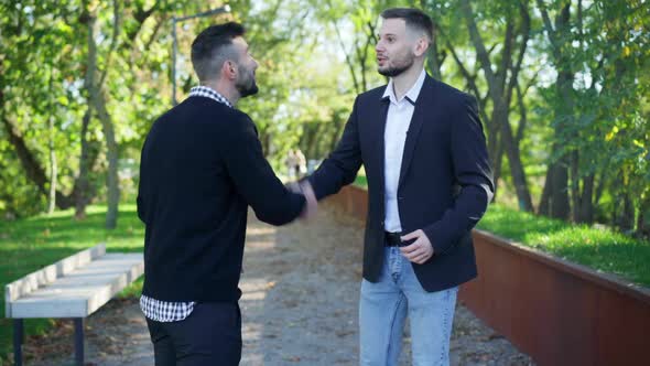 Two Men Shaking Hands Saying Goodbye Walking to Different Directions