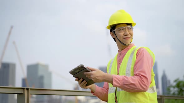 Engineer or construction worker man is types on a tablet and working concentrated at building plan