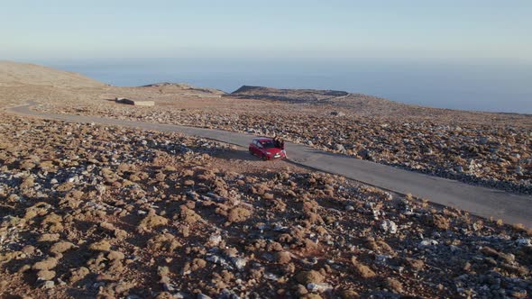 Friends travel concept. Two young girls tourists walking along an empty rocky rural road