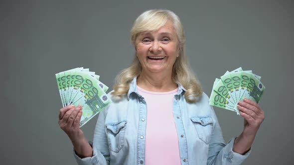 Joyful Senior Female Showing Euro Banknotes, Quick Loan Service, Wealth Concept