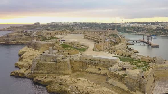 Aerial footage of the medieval Fort Ricasoli and the lighthouse from Malta's Grand Harbour.  The for