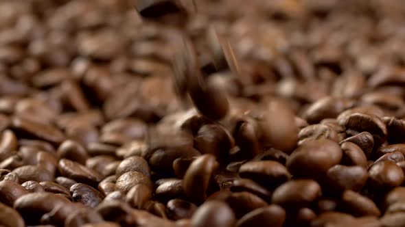 Brown Fried Coffee Beans Are Poured From Above To a Pile. Slow Motion Shot