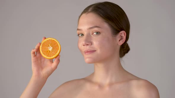 Young healthy girl with slices of orange citrus fruit