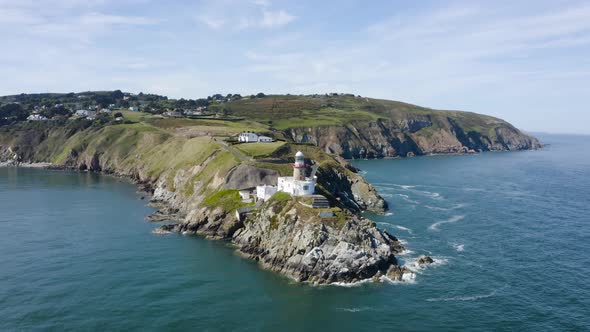 Flying around The Baily Lighthouse at Howth Head during a sunny day.