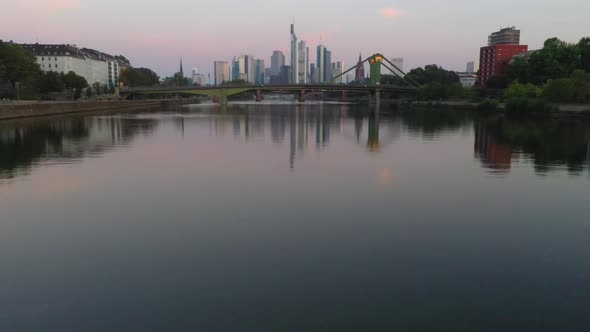 Drone movie flying towards Franklfurt skyline over the river Main during sunrise