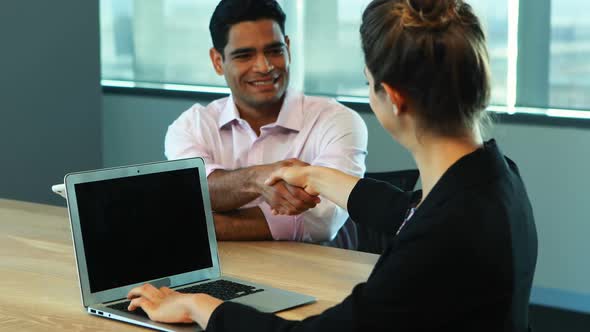 Businesswoman interacting with her colleague in conference room