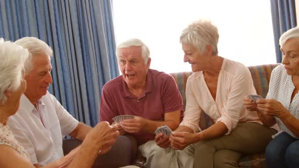 Group of senior friends playing cards