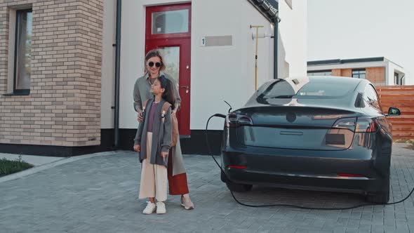 Portrait of Mother and Daughter with Electric Car