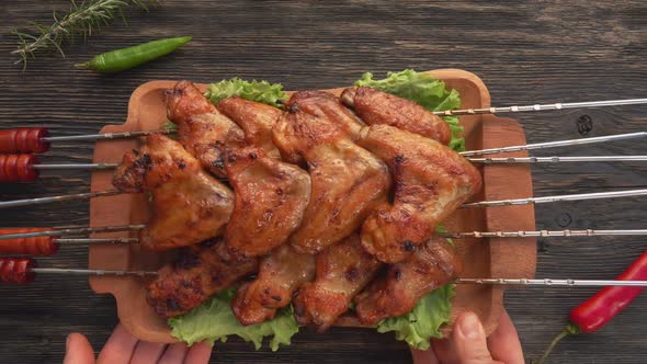 Top View of the Plate Full of Fried Chicken Wings on the Skewers Placed on Table